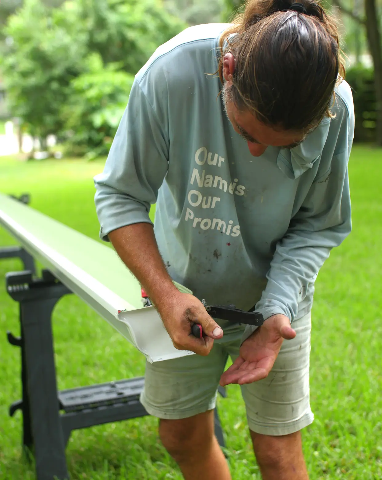 Crew member cutting the end cap of a gutter panel